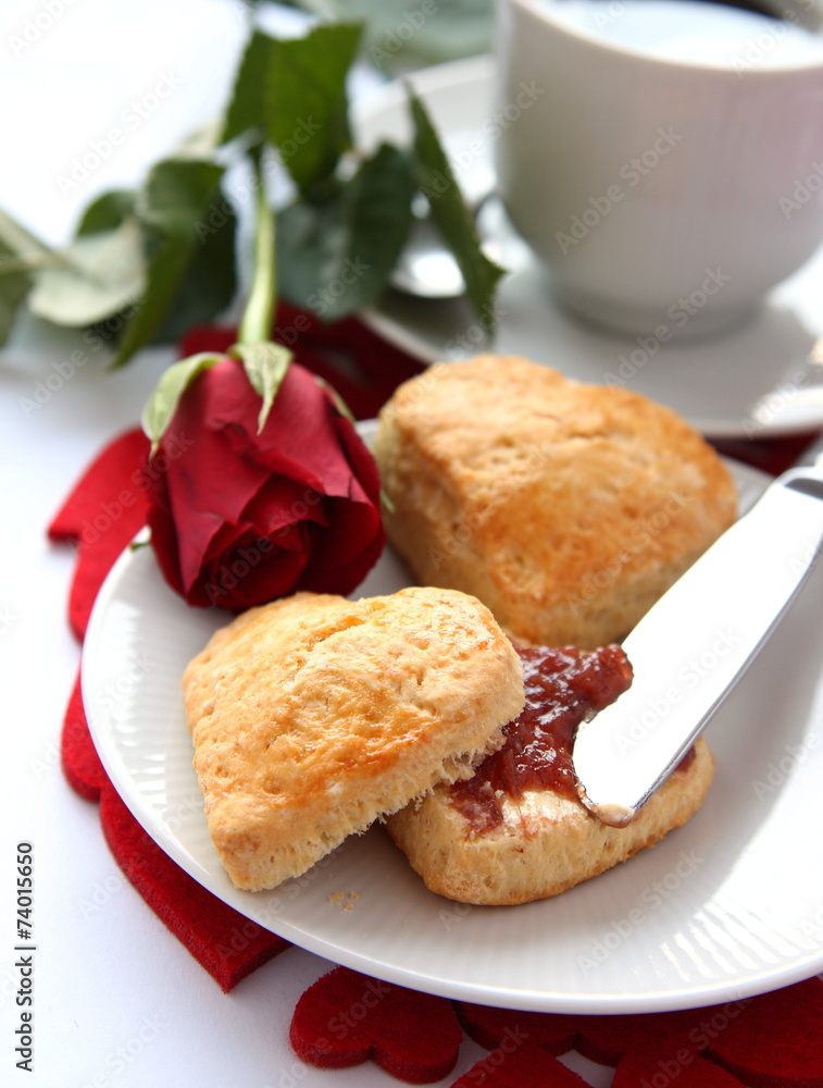 Heart shaped scones with strawberry jam and a cup of tea Heart shaped scones with strawberry jam and a cup of tea