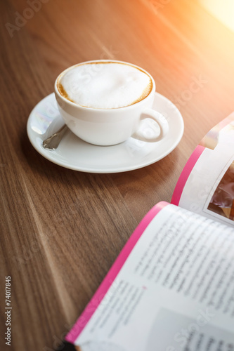 Coffee cup and book on the table