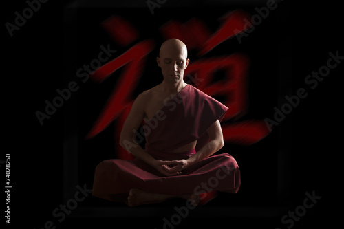 buddhist monk in meditation pose  with zen symbol on the backgro photo