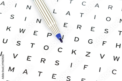 Blue Marker on solving crossword puzzle, close up