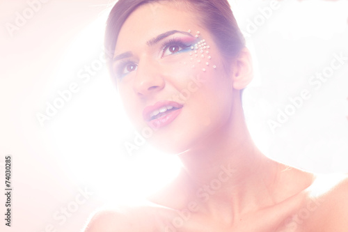 Beautiful woman posing in the studio wearing colorful make up