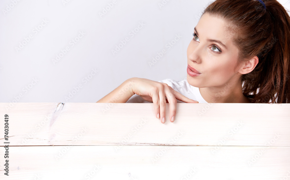 Beautiful woman holding sign. Image of woman standing behind woo Beautiful woman holding sign. Image of woman standing behind woo