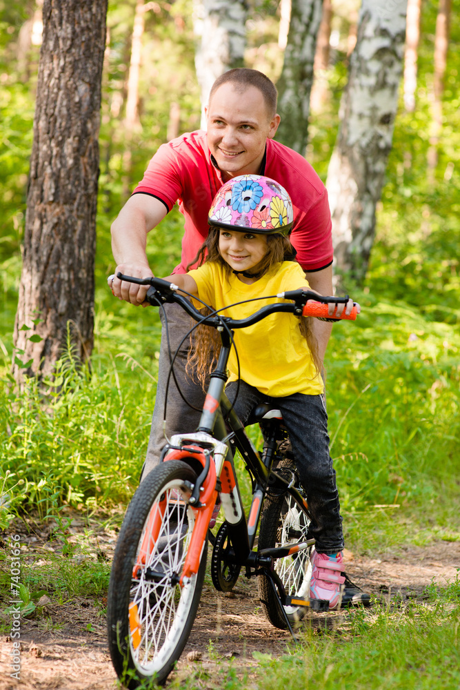 father teaching his daughter to ride a bike father teaching his daughter to ride a bike