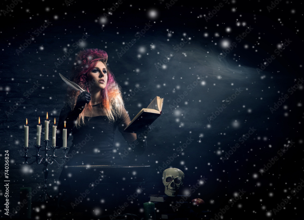 Beautiful witch making witchcraft over the smoky background Beautiful witch making witchcraft over the smoky background
