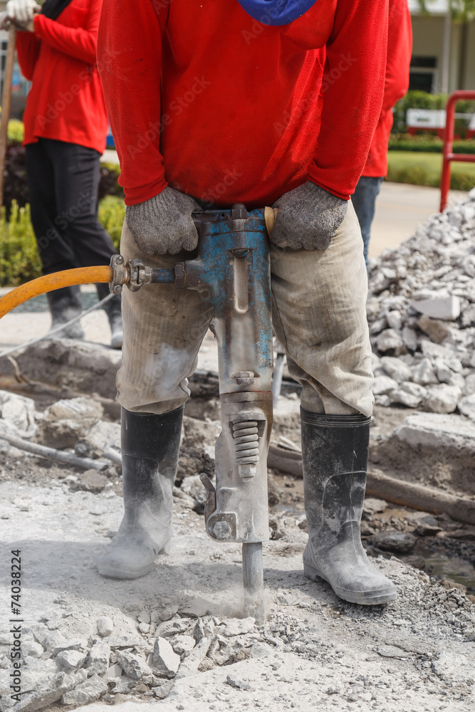 worker using construction drilling cement on the ground worker using construction drilling cement on the ground