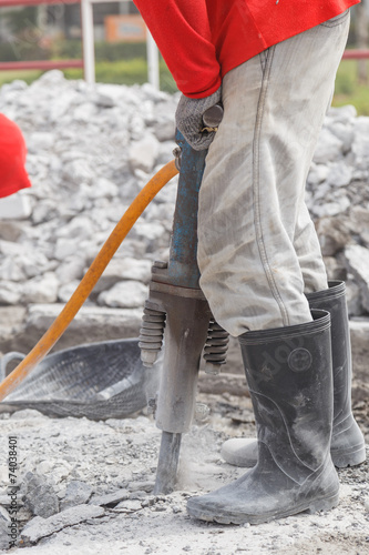 worker using construction drilling cement on the ground