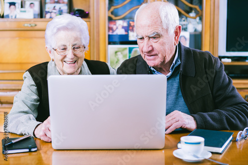 Senior couple working with Laptop at home © photopitu