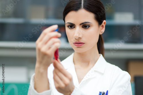 Fototapeta Naklejka Na Ścianę i Meble -  Female researcher analyzing a test tube