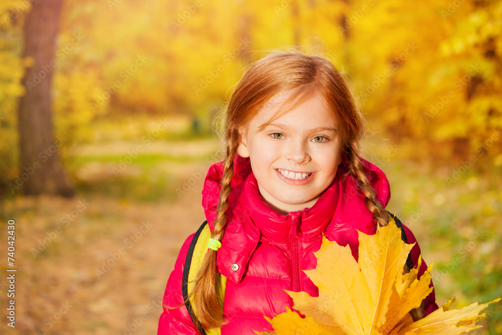 Close-up view of girl with rucksack and maple leaf Close-up view of girl with rucksack and maple leaf