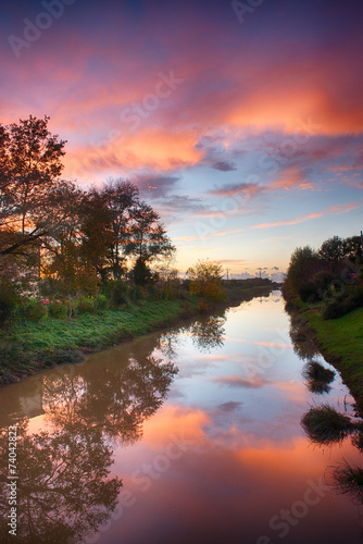 Wonderful sunset colors of fall with river reflections © jovannig