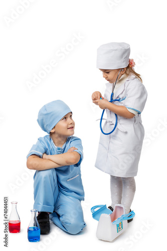 Картината върху платно Kids with stethoscope playing in a doctor, isolated on white