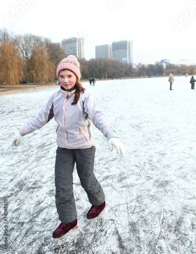 beautiful preteen girl figure skating in open winter skating rin photo