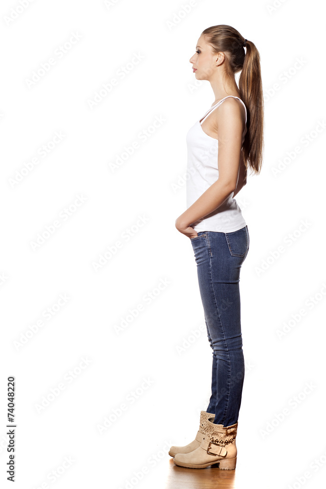 Side view of beautiful young woman in jeans and boots Side view of beautiful young woman in jeans and boots