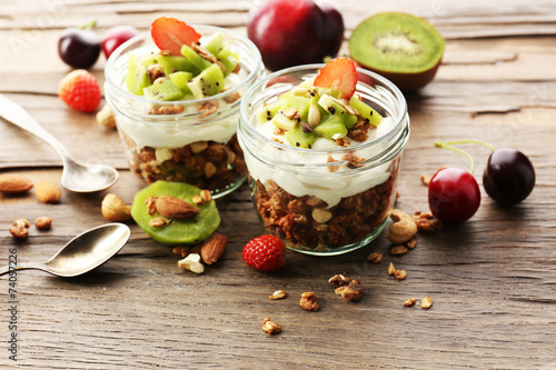 Healthy layered dessert with muesli and fruits on table