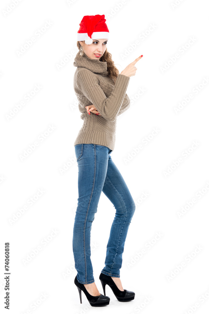 Young woman in a sweater and jeans pointing the finger side.