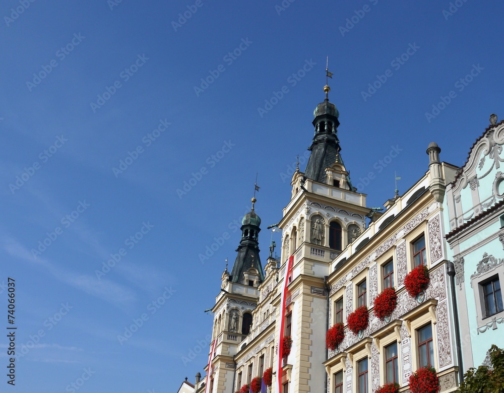 Ornamented building with flags and flowers on windows