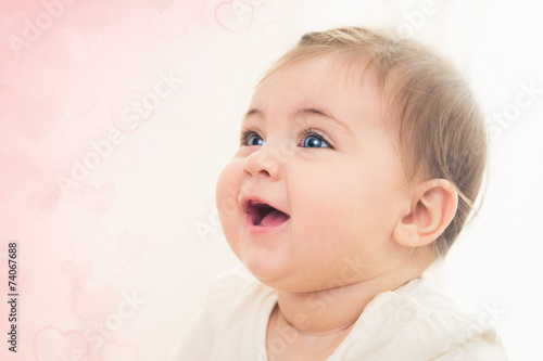 Close up shot of happy smiling baby girl with blue eyes. Soft fo