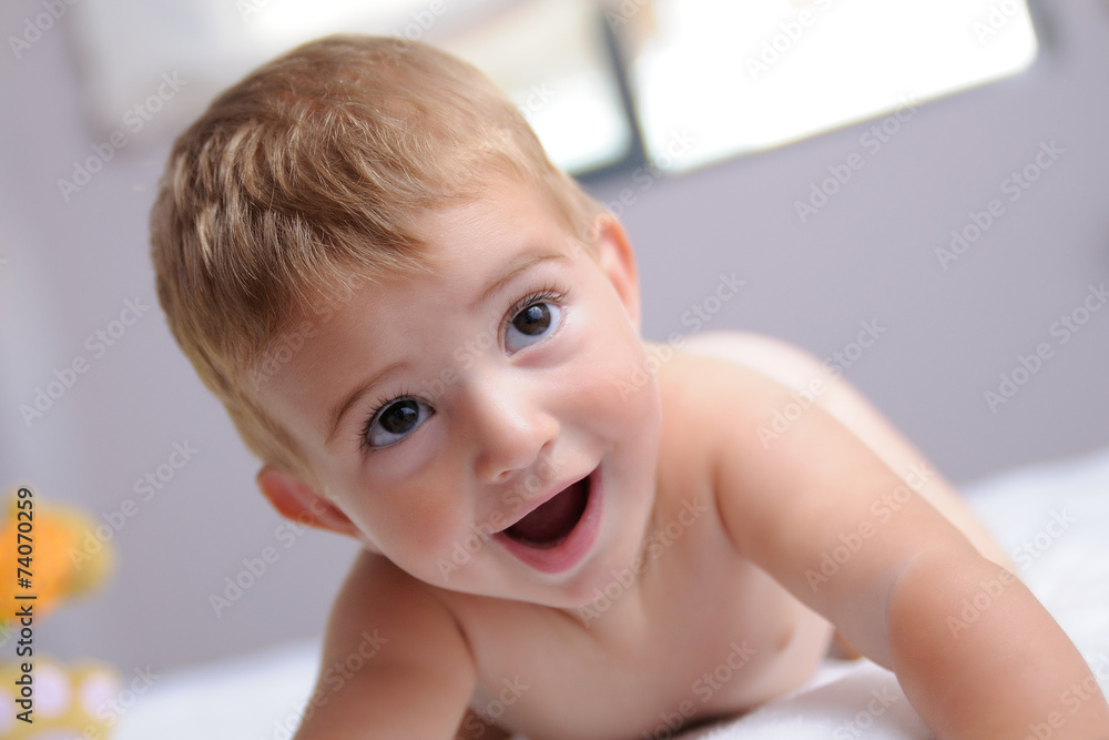 cheerful blond baby on a bed cheerful blond baby on a bed