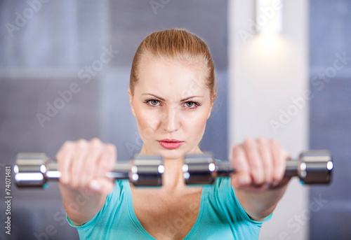 Young woman exercising with dumbbells