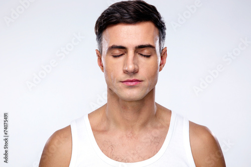 Handsome man with closed eyes over gray background
