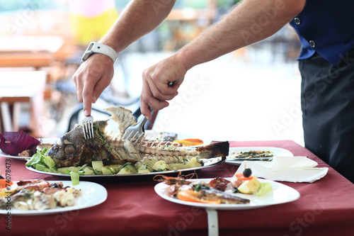 fish restaurant, fish is cut, the waiter hands