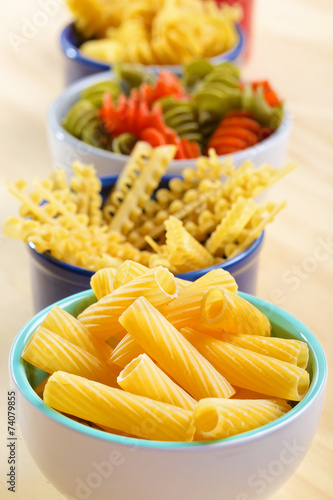 Variety of uncooked italian pasta on wooden table photo