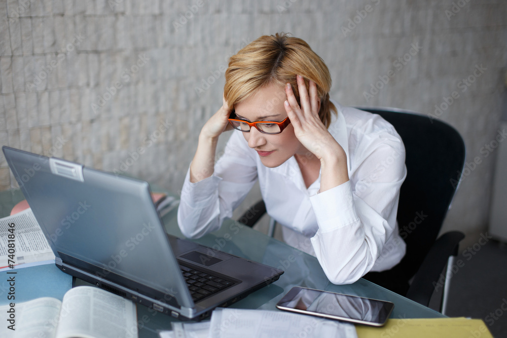 Stressed blonde businesswoman with laptop