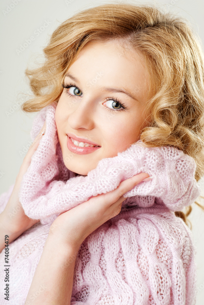 cheerful blond woman in a pink sweater. the winter season.