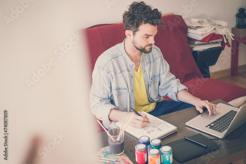 handsome hipster modern man working home using laptop