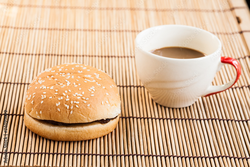 hamburgers and cup of black coffee on wooden board. hamburgers and cup of black coffee on wooden board.