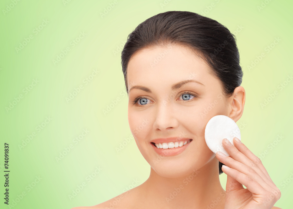 smiling woman cleaning face skin with cotton pad smiling woman cleaning face skin with cotton pad