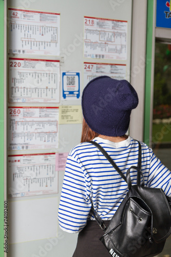 Woman at bus stop looking at timetable