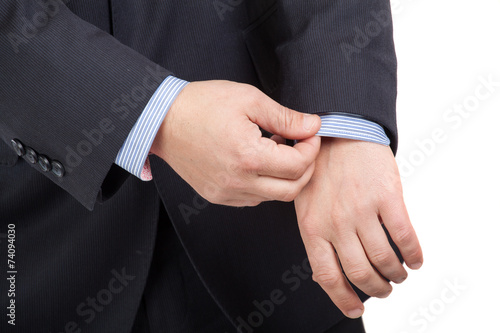 Closeup of a man in suit correcting a sleeve