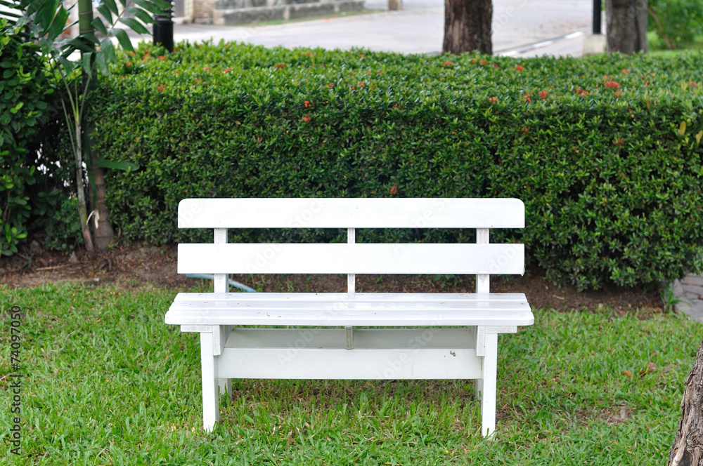 Single white bench in garden for relaxing.