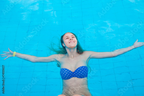Девушка плавает в бассейне