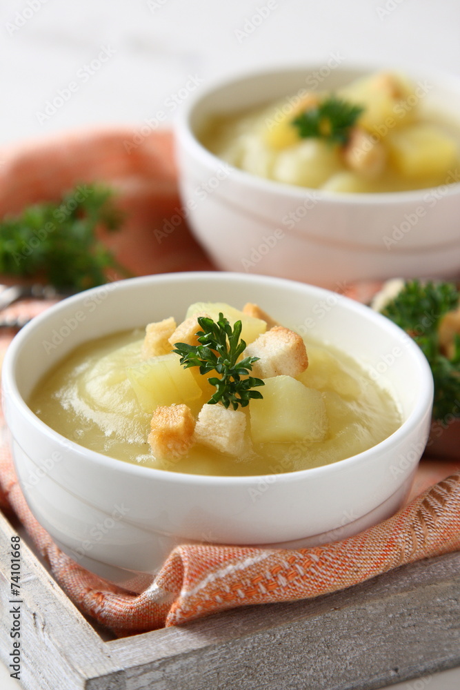 Bowl of creamy sweet potato soup with croutons on wooden tray Bowl of creamy sweet potato soup with croutons on wooden tray