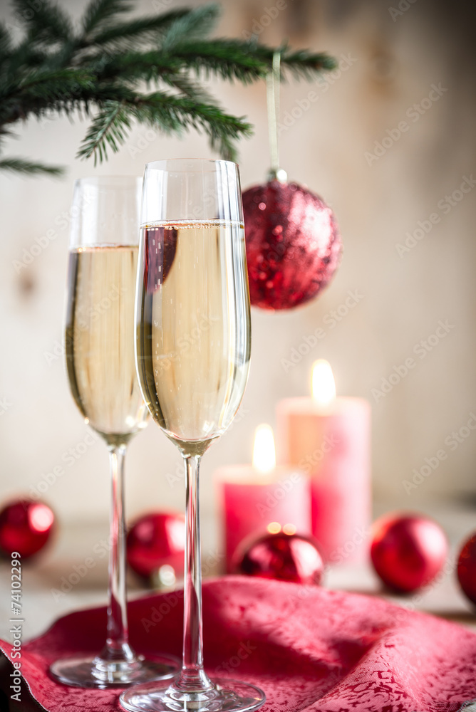 Glasses of champagne under decorated christmas tree branch Glasses of champagne under decorated christmas tree branch