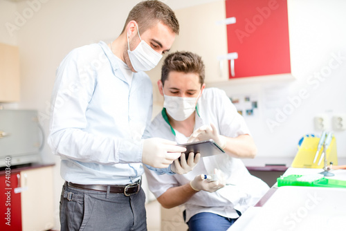 scientists looking at tablet and working on test experiments