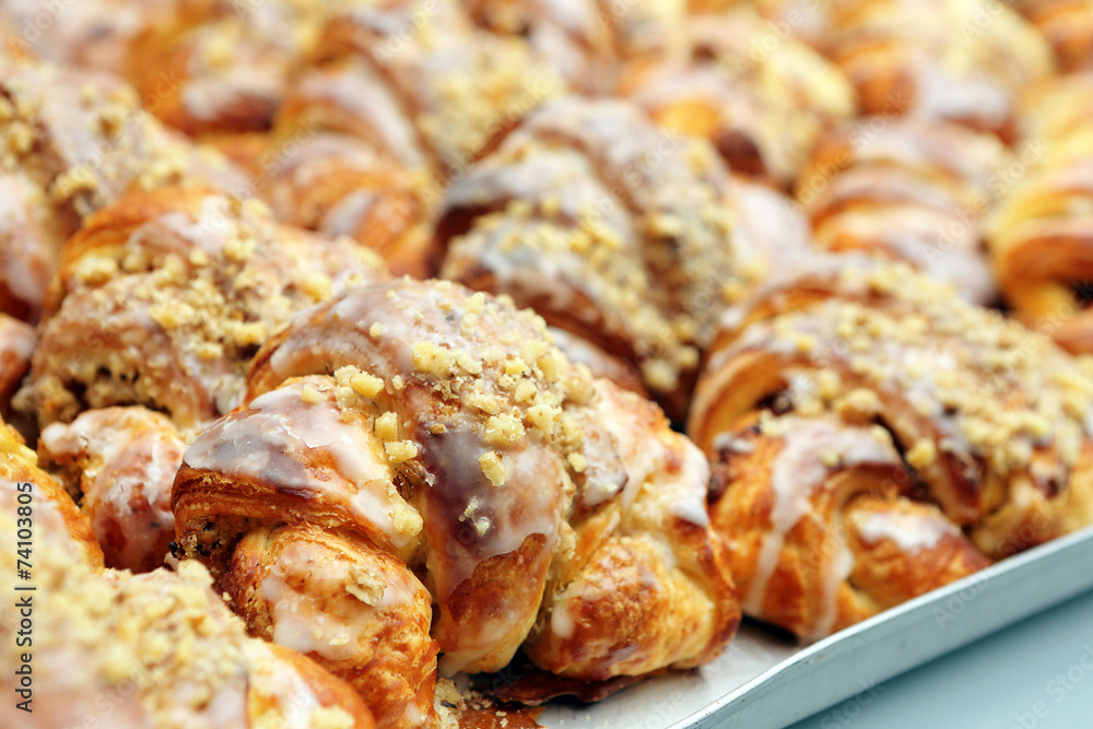 Croissants with sweet icing and walnuts in a bakery
