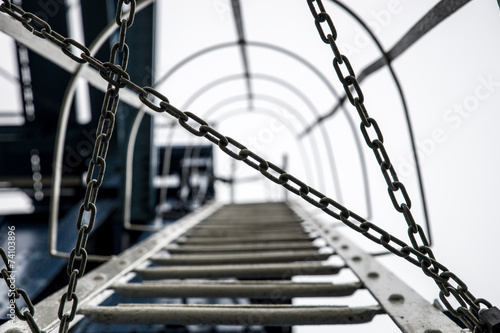the way up a metal ladder blocked by a chain