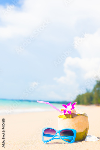 Fototapeta Naklejka Na Ścianę i Meble -  picture of cocnut cocktail and sunglasses on tropical beach