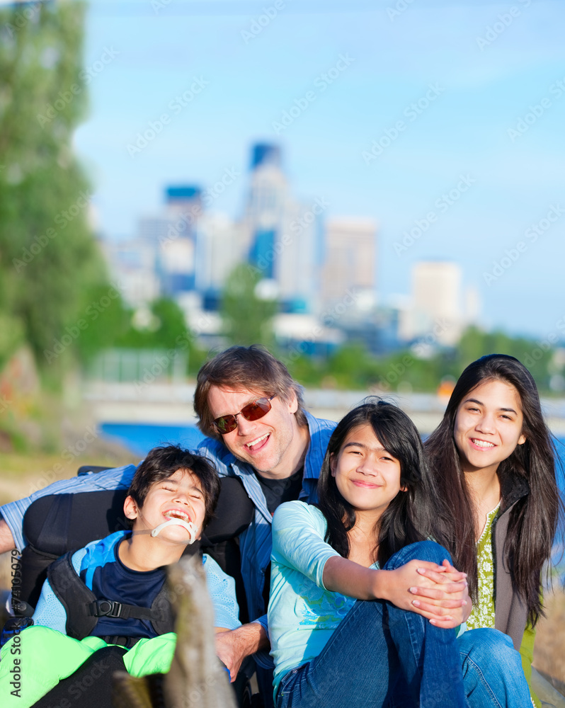 Fototapeta premium Disabled boy in wheelchair with family outdoors on sunny day, wi
