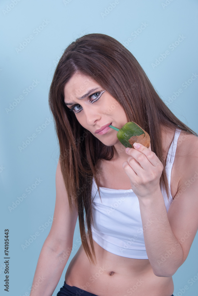 Healthy and elegant young woman, holding a kiwi with straw Healthy and elegant young woman, holding a kiwi with straw