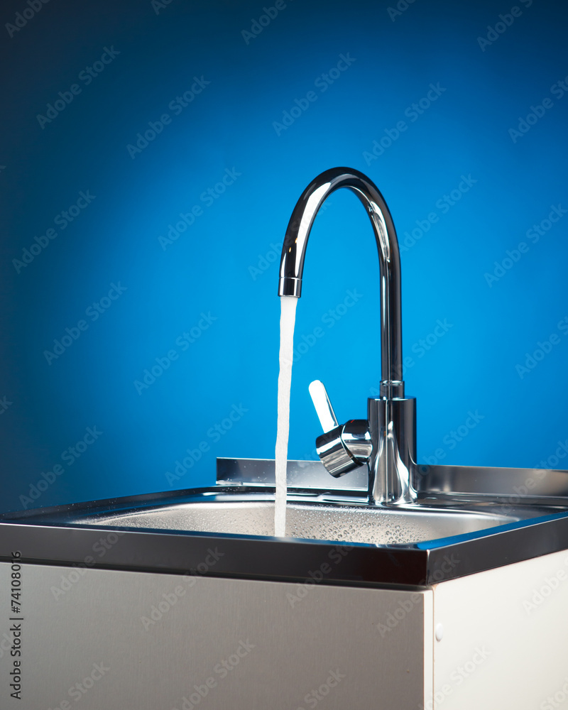 mixer tap with flowing water, blue background mixer tap with flowing water, blue background