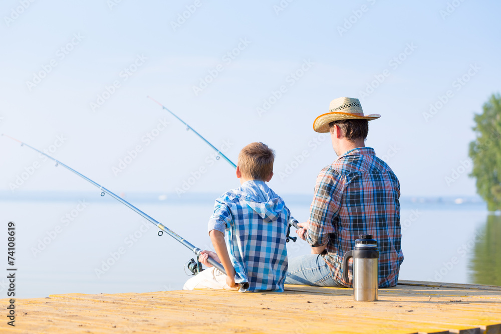 boy and his father fishing togethe