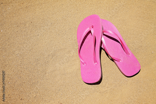  summer vacation background with a pair of sandals on a sandy beach