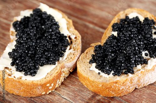 Slices of bread with butter and black caviar