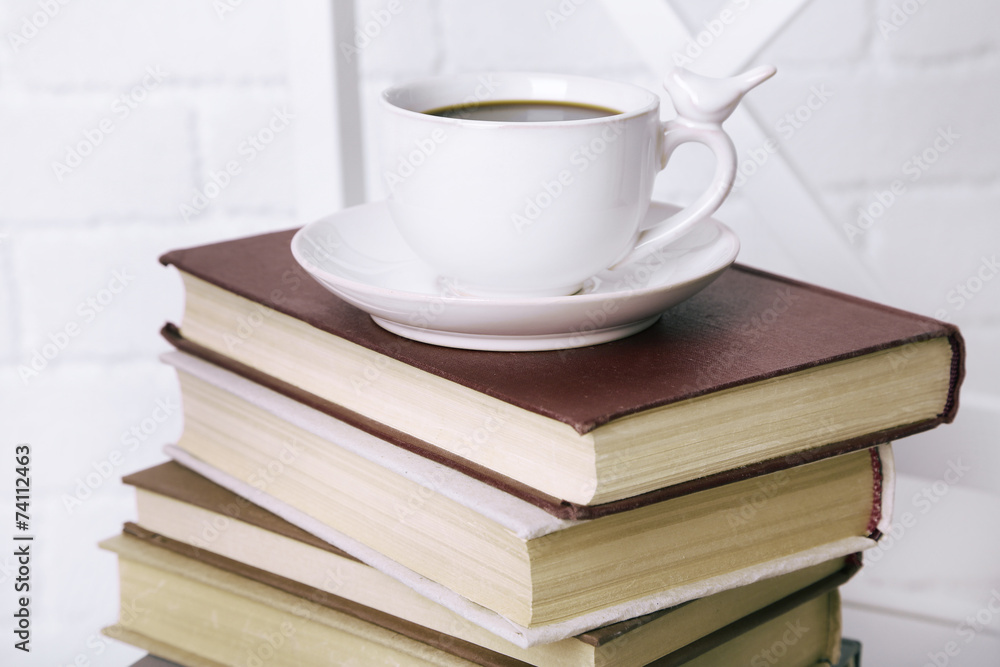 Naklejka premium Old books and cup of coffee on table