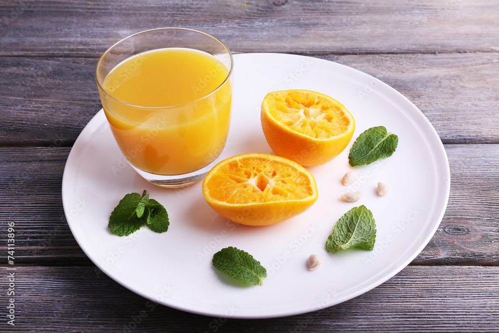 Glass of juice and ripe sweet tangerine on wooden table Glass of juice and ripe sweet tangerine on wooden table