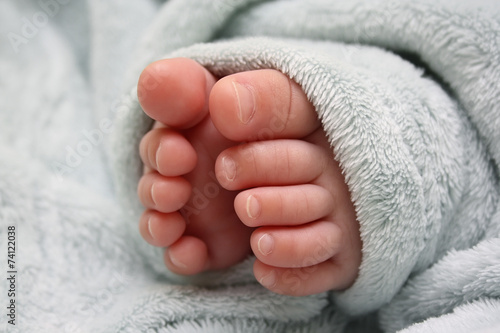Legs of the sleeping baby in blue fluffy blanket